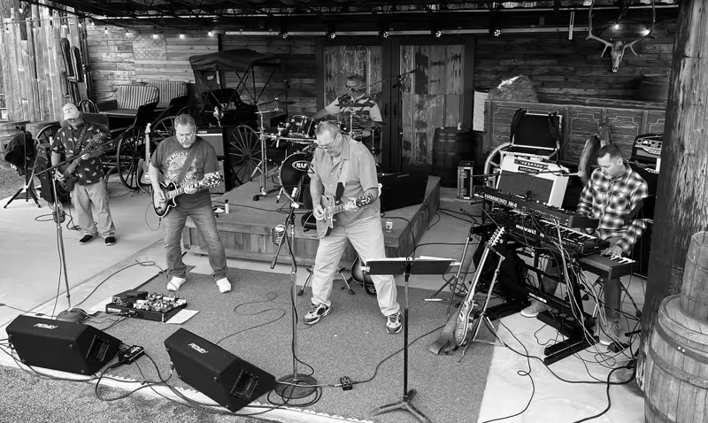 The full band on an outdoor stage