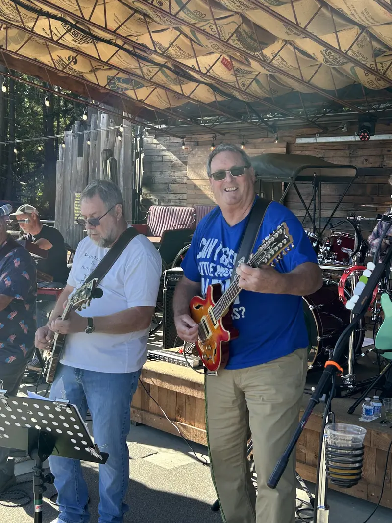 Two guitarists smiling mid-song